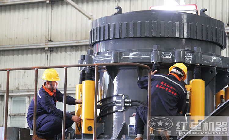 工作人員檢測圓錐破碎機(jī)，保障生產(chǎn)的設(shè)備都有高質(zhì)量